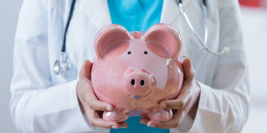 Doctor holding piggy bank to show healthcare costs